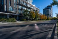 an empty street in a modern city with tall buildings in the background and blue sky above