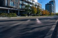 an empty street in a modern city with tall buildings in the background and blue sky above