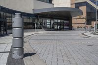 a person sitting at the bench in front of a mall that is empty of people