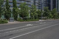 the empty city street is surrounded by tall buildings and green trees in the middle of a deserted city