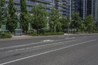 the empty city street is surrounded by tall buildings and green trees in the middle of a deserted city