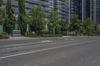 the empty city street is surrounded by tall buildings and green trees in the middle of a deserted city