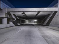 an empty parking garage with no people in it at night time time with only one stop sign