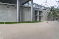 a street light is outside of an urban building with concrete walls and grass and trees