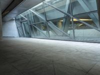 a photo inside an open space with large windows looking outside and empty flooring with white marble tile