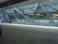 a photo inside an open space with large windows looking outside and empty flooring with white marble tile