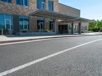 an empty parking lot is at the bottom of a road with a bus station above it