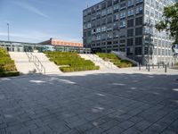 a long stairway leads up to the top of an outdoor park and plaza with landscaping along one side of the stairs