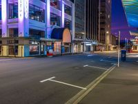 a night time scene with a street light and buildings around it that is empty for all to see