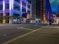 a night time scene with a street light and buildings around it that is empty for all to see