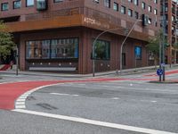 the two traffic lights are red and the intersection is blue and white and with a building with three floors