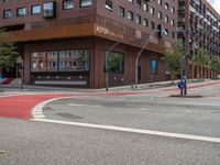 the two traffic lights are red and the intersection is blue and white and with a building with three floors