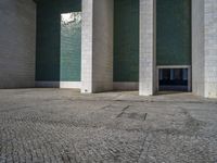 an empty area with some kind of building in the background, near concrete pillars and windows