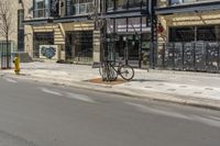 the side walk of a storefront with a bike sitting on the sidewalk and a fire hydrant