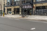 the side walk of a storefront with a bike sitting on the sidewalk and a fire hydrant