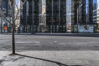 an empty sidewalk near the side of a building in the city of tall buildings and a traffic light