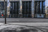 an empty sidewalk near the side of a building in the city of tall buildings and a traffic light