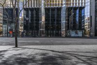 an empty sidewalk near the side of a building in the city of tall buildings and a traffic light