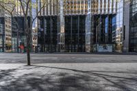 an empty sidewalk near the side of a building in the city of tall buildings and a traffic light