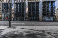 an empty sidewalk near the side of a building in the city of tall buildings and a traffic light