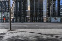 an empty sidewalk near the side of a building in the city of tall buildings and a traffic light