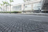 a black car driving down a road on top of bricks next to tall buildings,