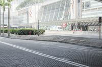 a black car driving down a road on top of bricks next to tall buildings,