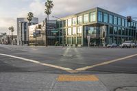 an empty street with a yellow crosswalk sign on the side of it, and two buildings in the back