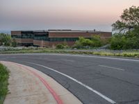 a building that has a bunch of windows on it at sunset with mountains in the background