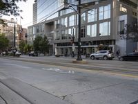 an empty street next to buildings and a bus stop sign with red and white numbers