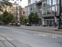 an empty street next to buildings and a bus stop sign with red and white numbers