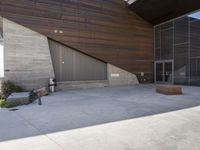 a person standing outside of a very nice building on a sunny day looking at their cell phone