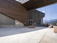 a person standing outside of a very nice building on a sunny day looking at their cell phone