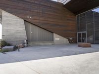 a person standing outside of a very nice building on a sunny day looking at their cell phone