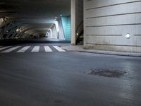 the side walk of an empty parking garage filled with parked cars and stairs, where people are walking towards a building