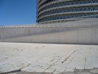 a black fire hydrant is sitting in the concrete area in front of a large building