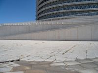 a black fire hydrant is sitting in the concrete area in front of a large building