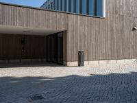 a building with doors and windows on it's sides with an open walkway and two fire hydrant in the center