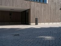 a building with doors and windows on it's sides with an open walkway and two fire hydrant in the center