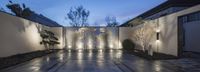 a courtyard with lighted fountains, trees and a walkway for the right and bottom level