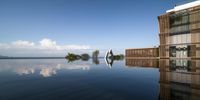 a large rectangular swimming pool sits empty with an edge missing to the ground, which can be seen in a blurry image