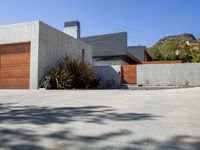 a gray concrete building with stairs and door at the top of the floor next to it is steps leading down to the doorway