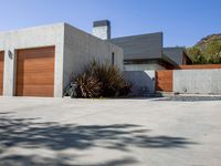 a gray concrete building with stairs and door at the top of the floor next to it is steps leading down to the doorway