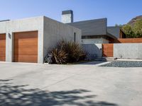 a gray concrete building with stairs and door at the top of the floor next to it is steps leading down to the doorway