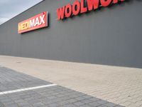 a view of a store front with a red and yellow sign on the side of the building