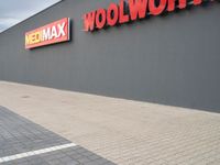 a view of a store front with a red and yellow sign on the side of the building