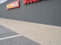 a view of a store front with a red and yellow sign on the side of the building