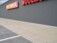 a view of a store front with a red and yellow sign on the side of the building