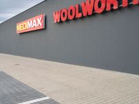 a view of a store front with a red and yellow sign on the side of the building