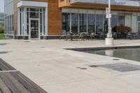 wooden benches sit near a water front and patio area next to the building and patio